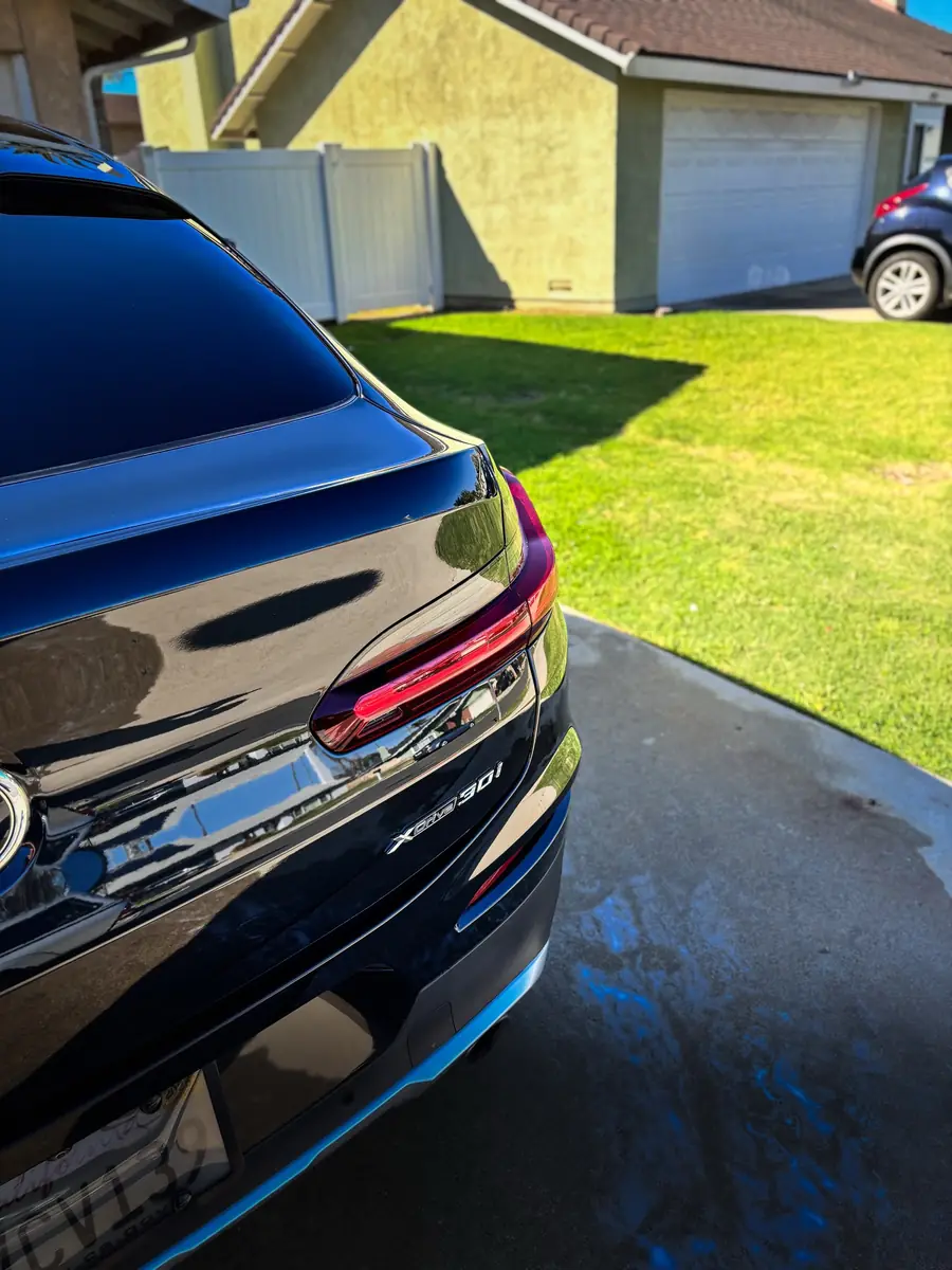Glossy black BMW X4 rear three-quarter after detailing