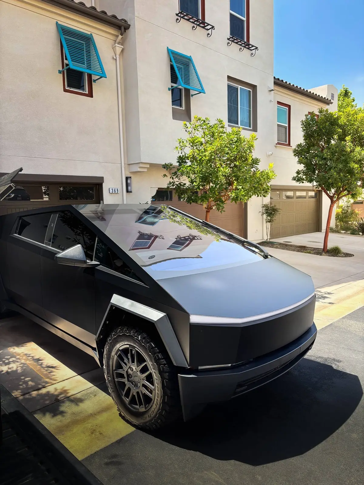 Matte black Cybertruck freshly detailed in a driveway