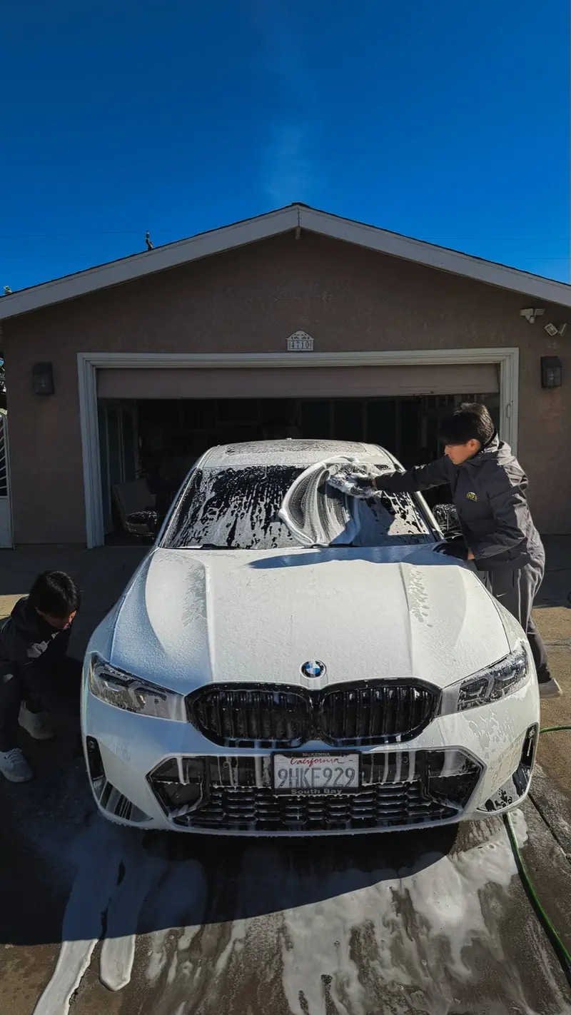 DD's crew foam-washing a white BMW during a full detail