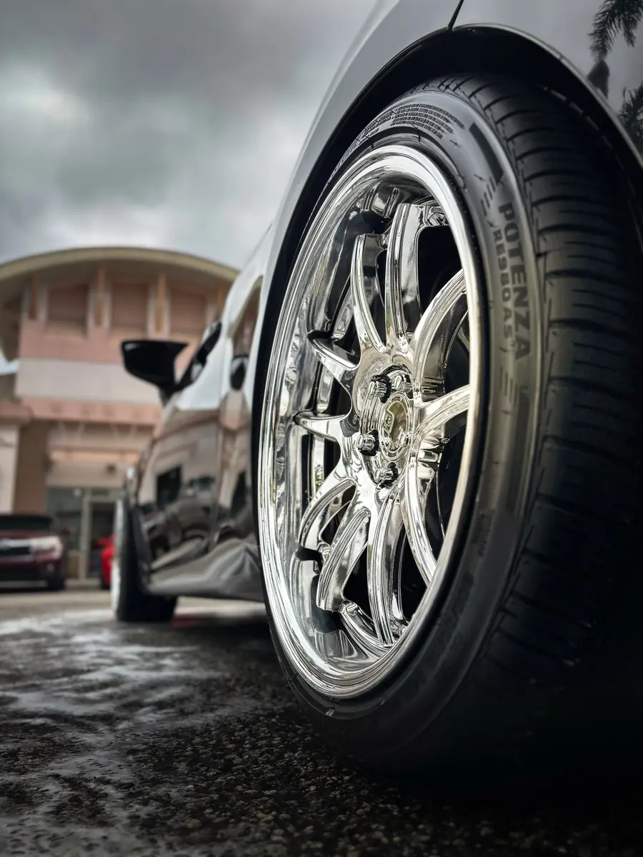 Polished forged wheel under a dramatic sky after a wheel detail