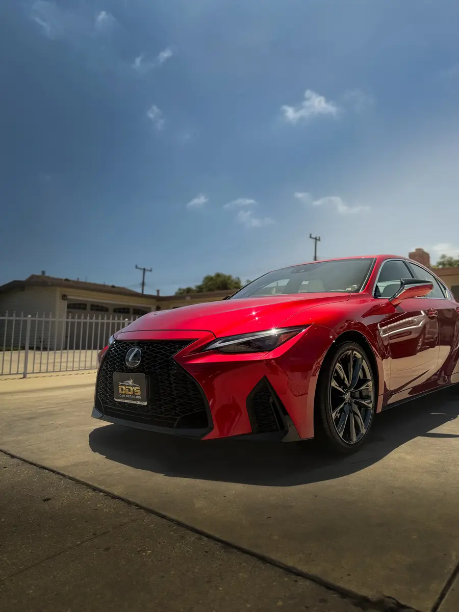 Red Lexus IS 350 F Sport shining under blue sky