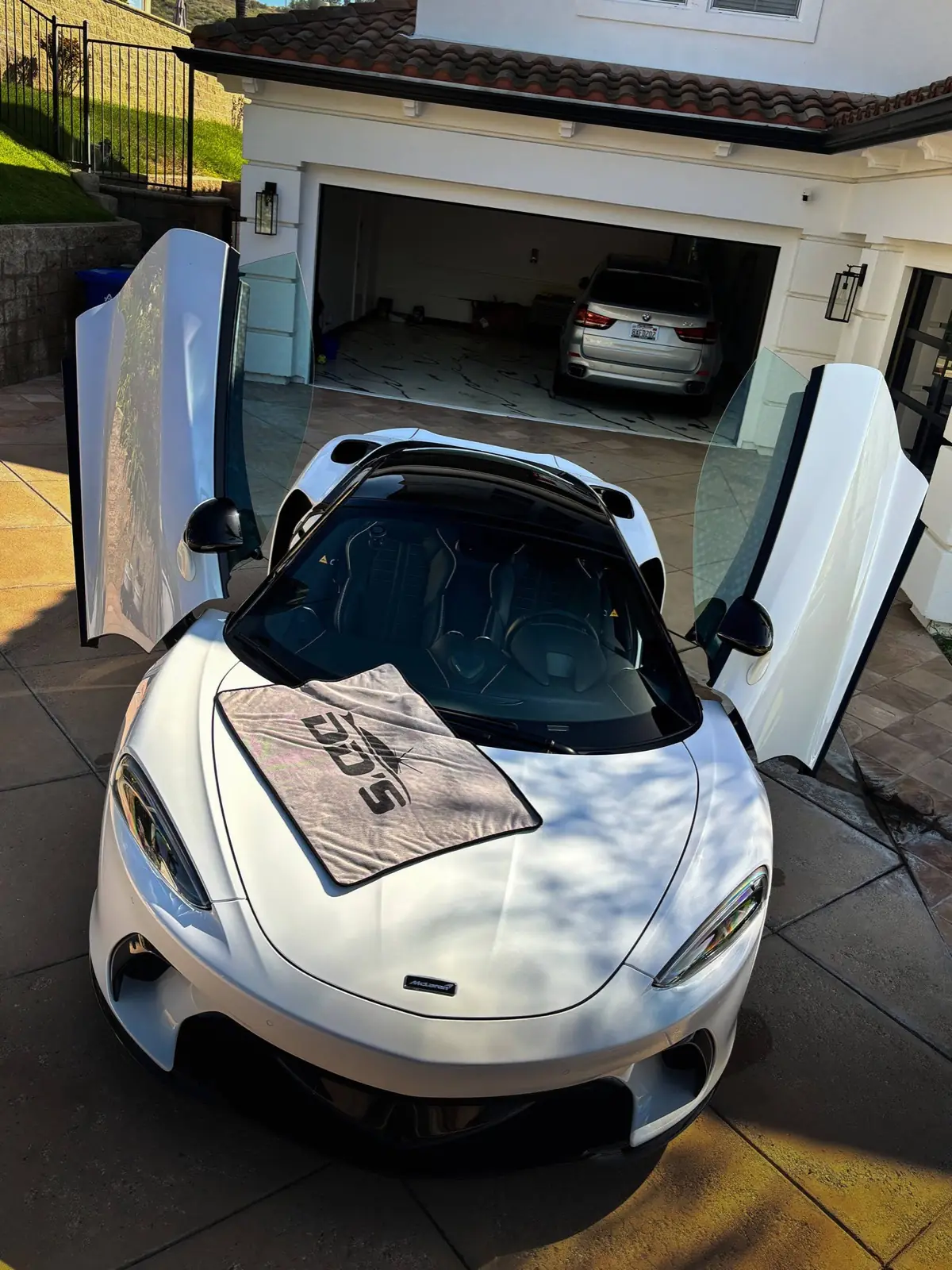 White McLaren GT with doors up after a DD's full detail