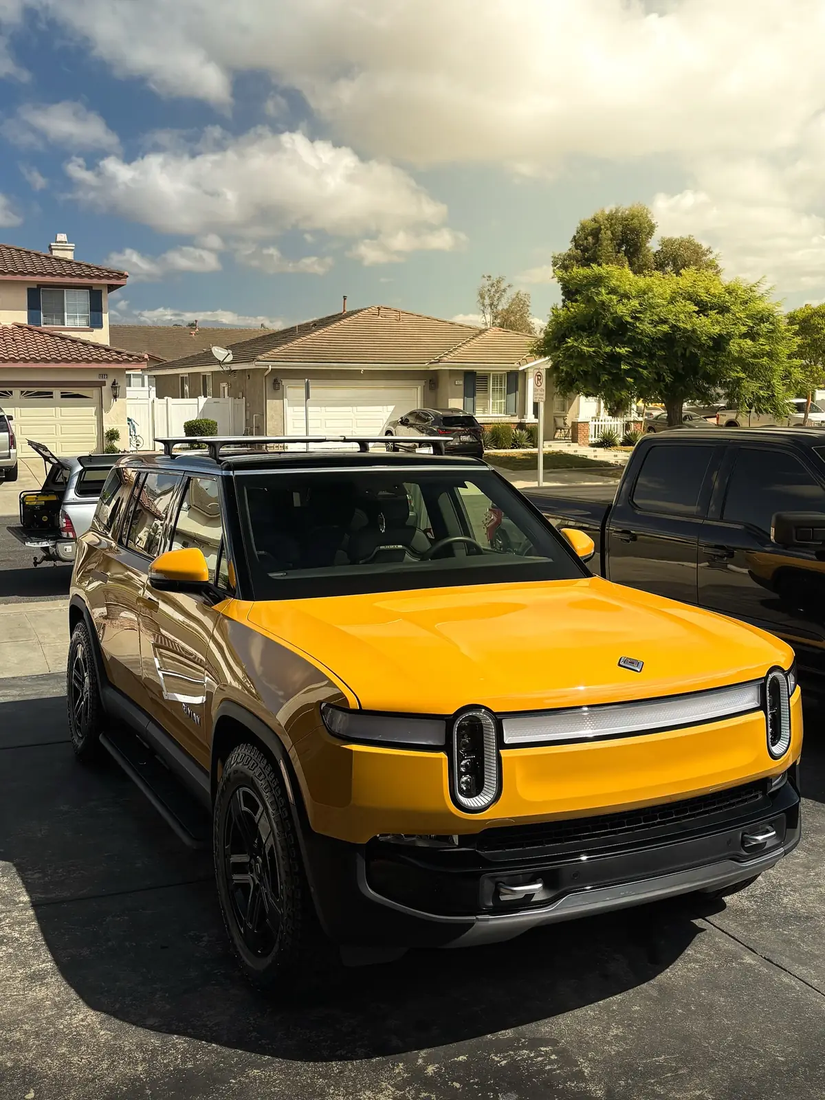 A yellow Rivian R1T freshly detailed in a driveway