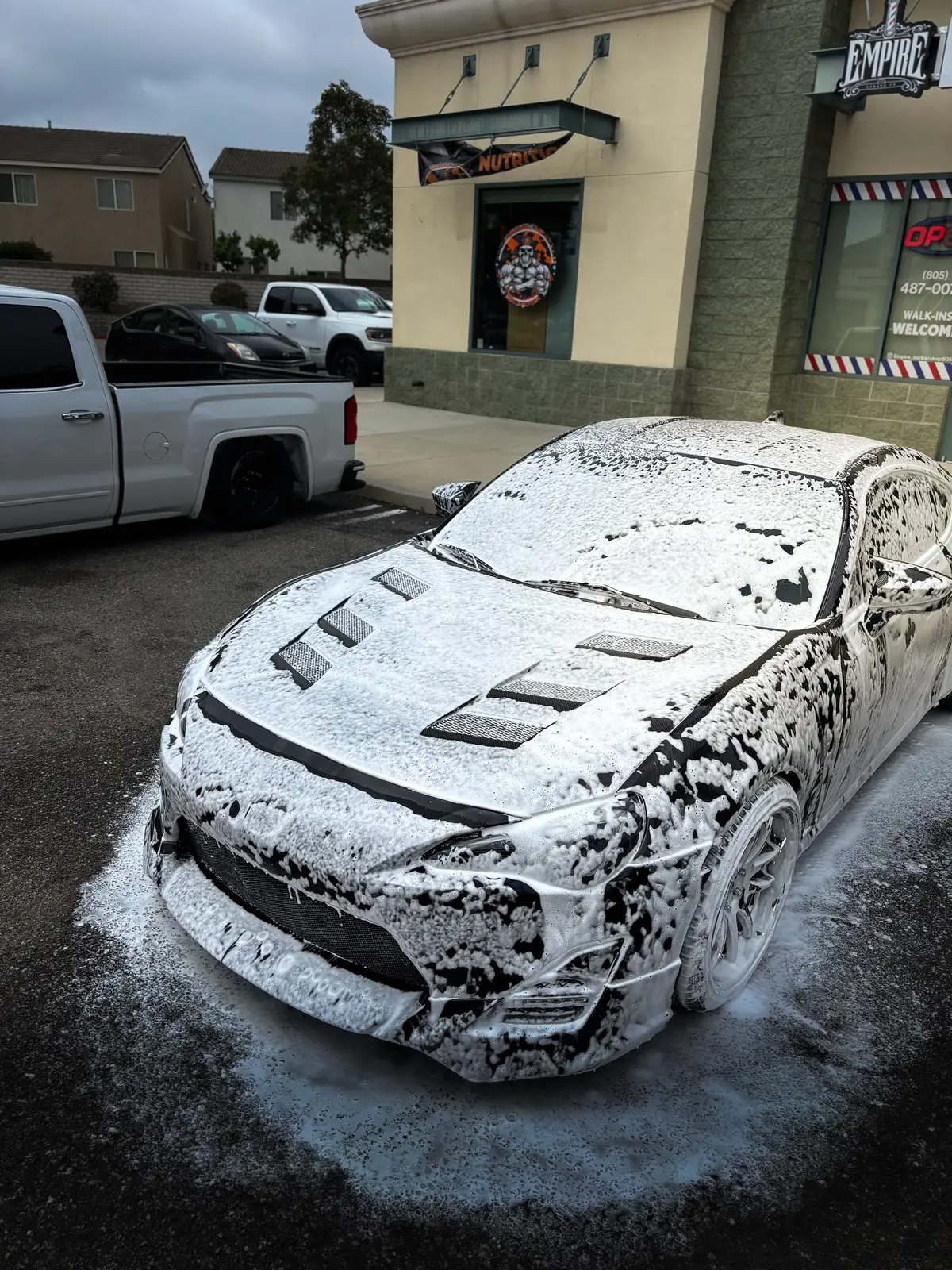 A Toyota 86 covered head to toe in thick wash foam