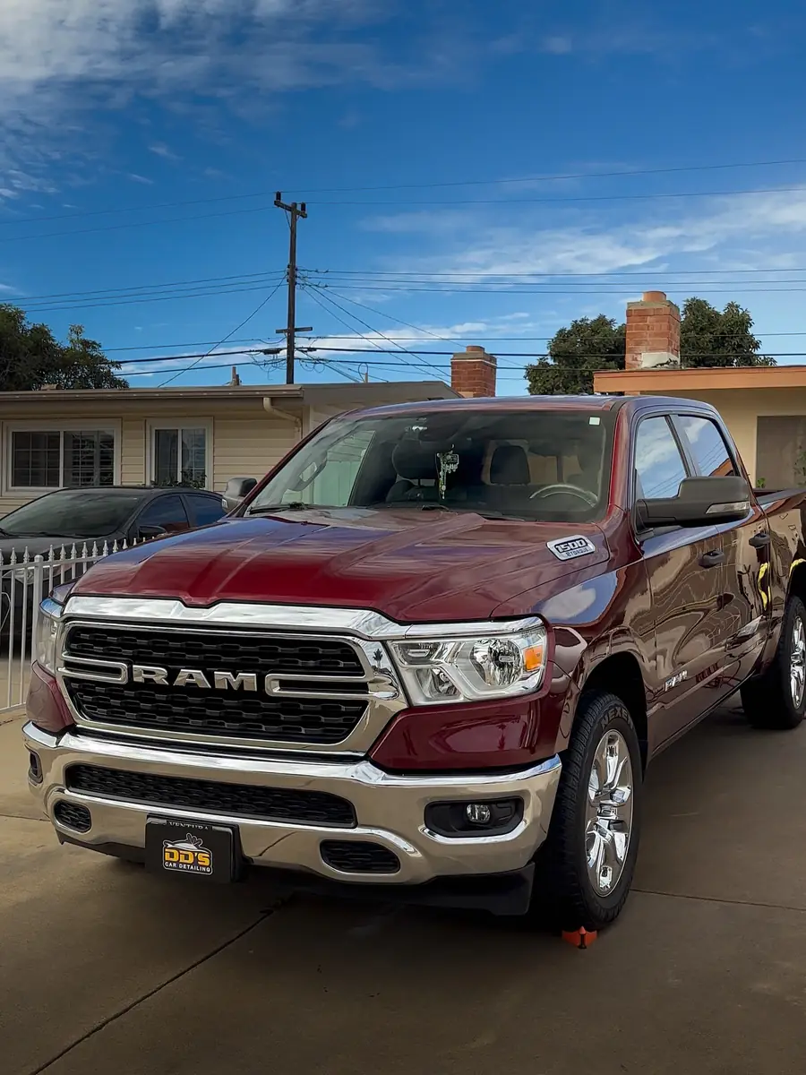 Dark red RAM 1500 pickup detailed in a driveway