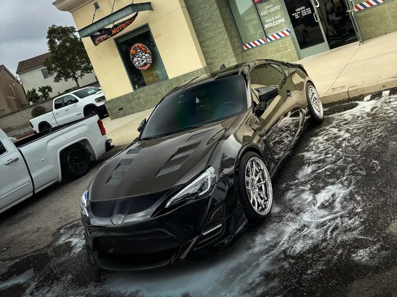 A freshly detailed black Toyota 86 gleaming after a full detail